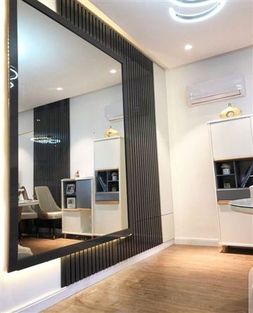 Wall mirror with cladding